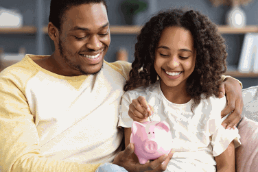 Father and daughter with piggy bank
